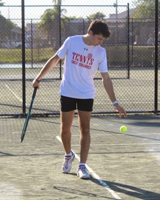 Coach Matheus preparing to serve on a tennis court